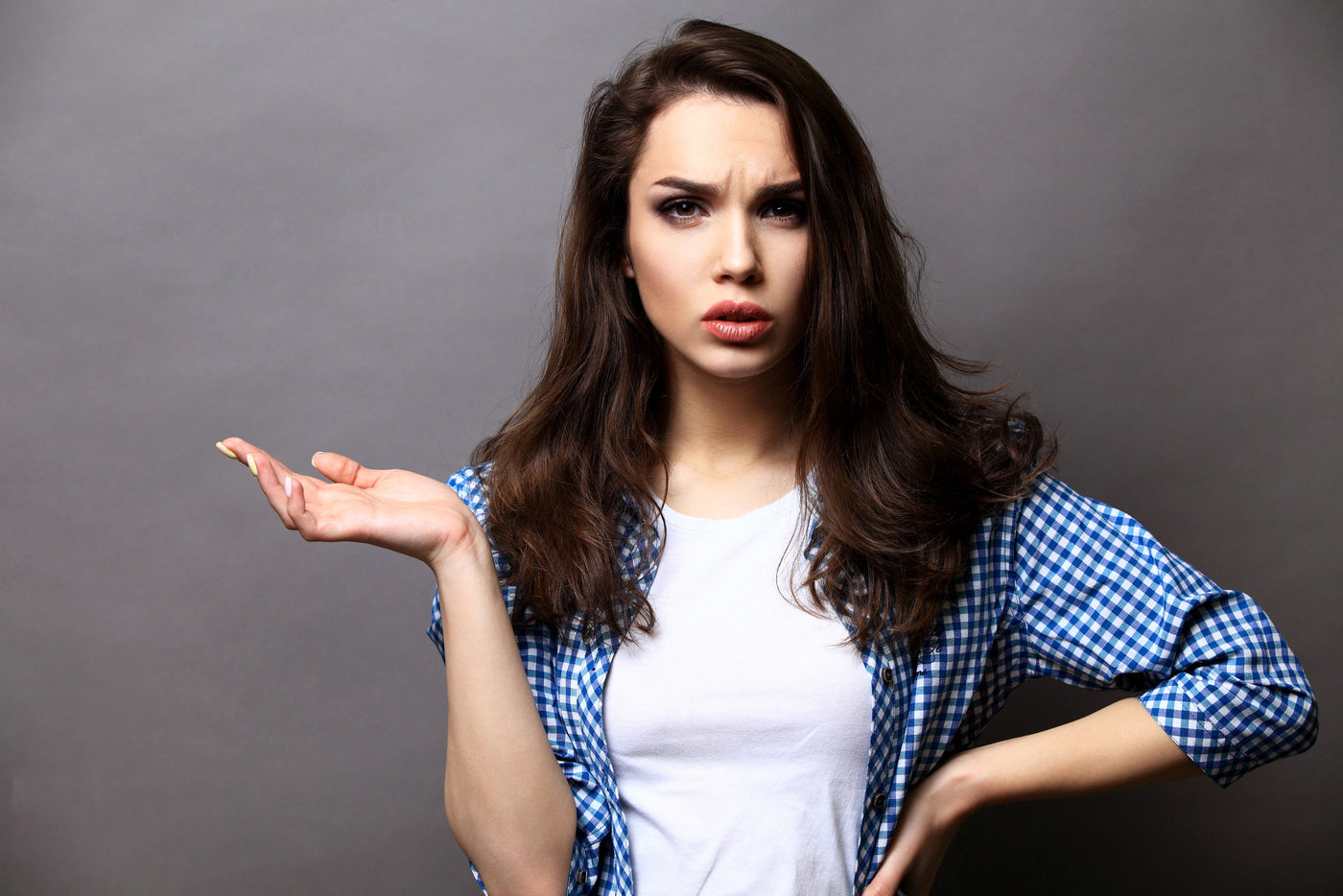 Woman holding one hand aloft as if to ask a question