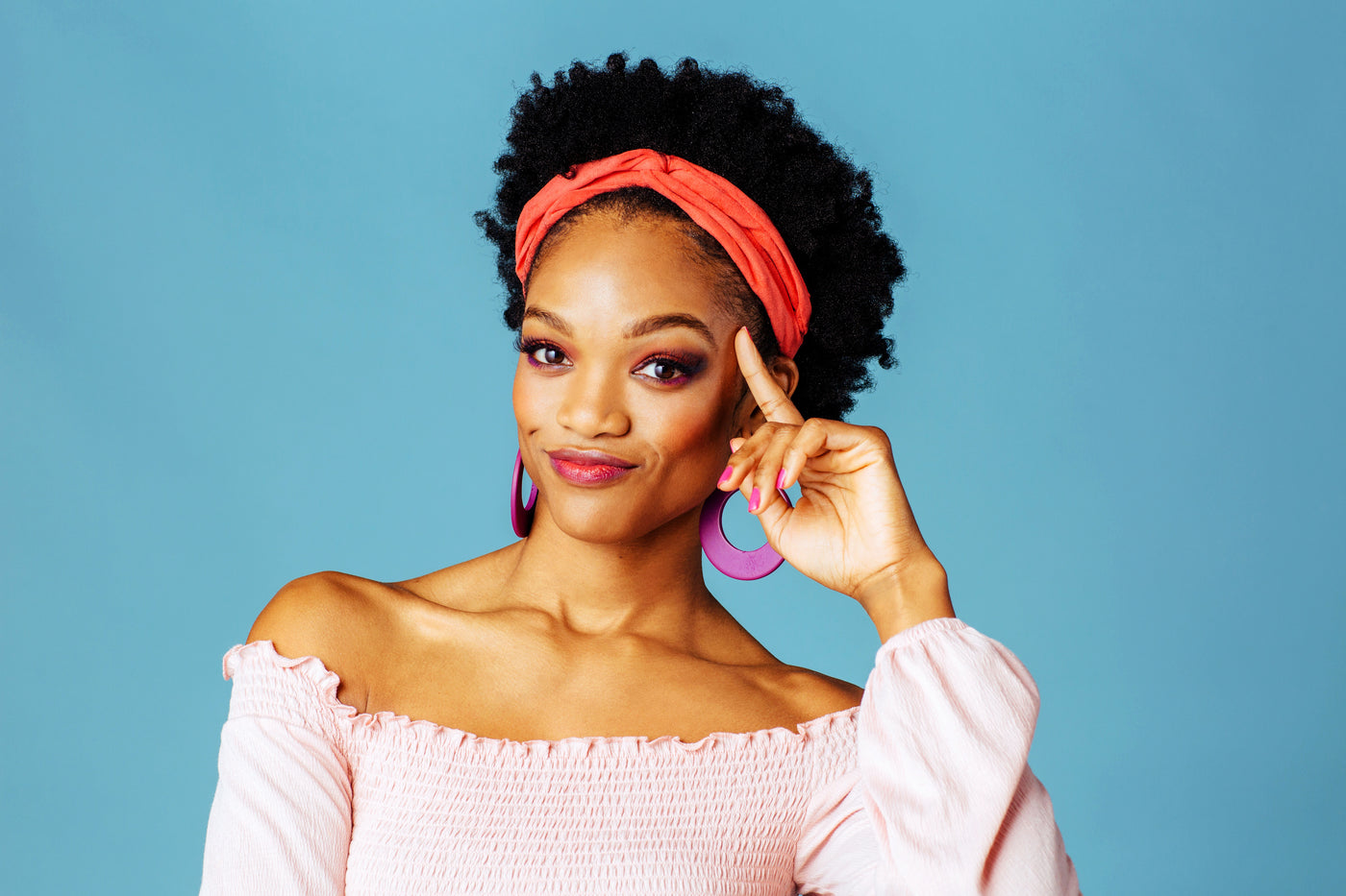 African American women pointing to her head to insinuate she has knowledge about something