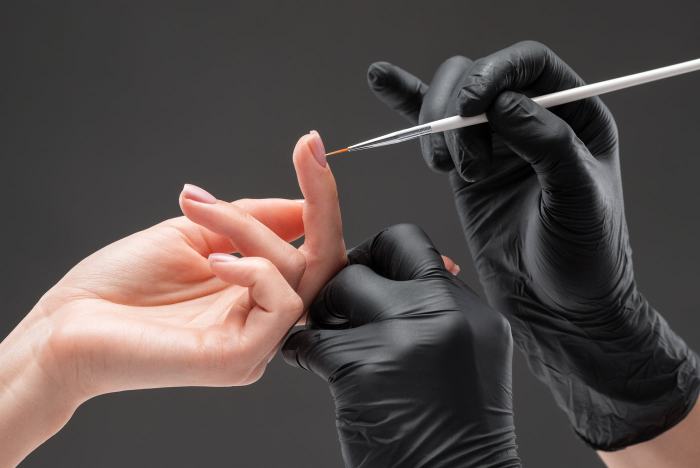 Nail art brush detailing a nail during a manicure 